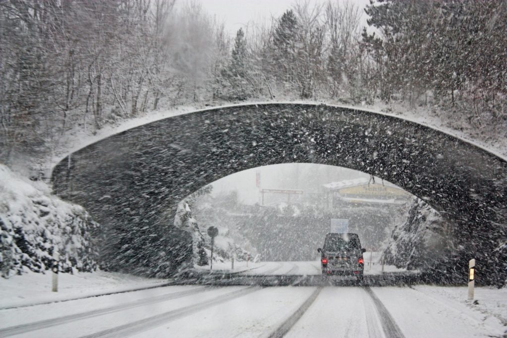 Car with winter tires driving through snow storm in alberta